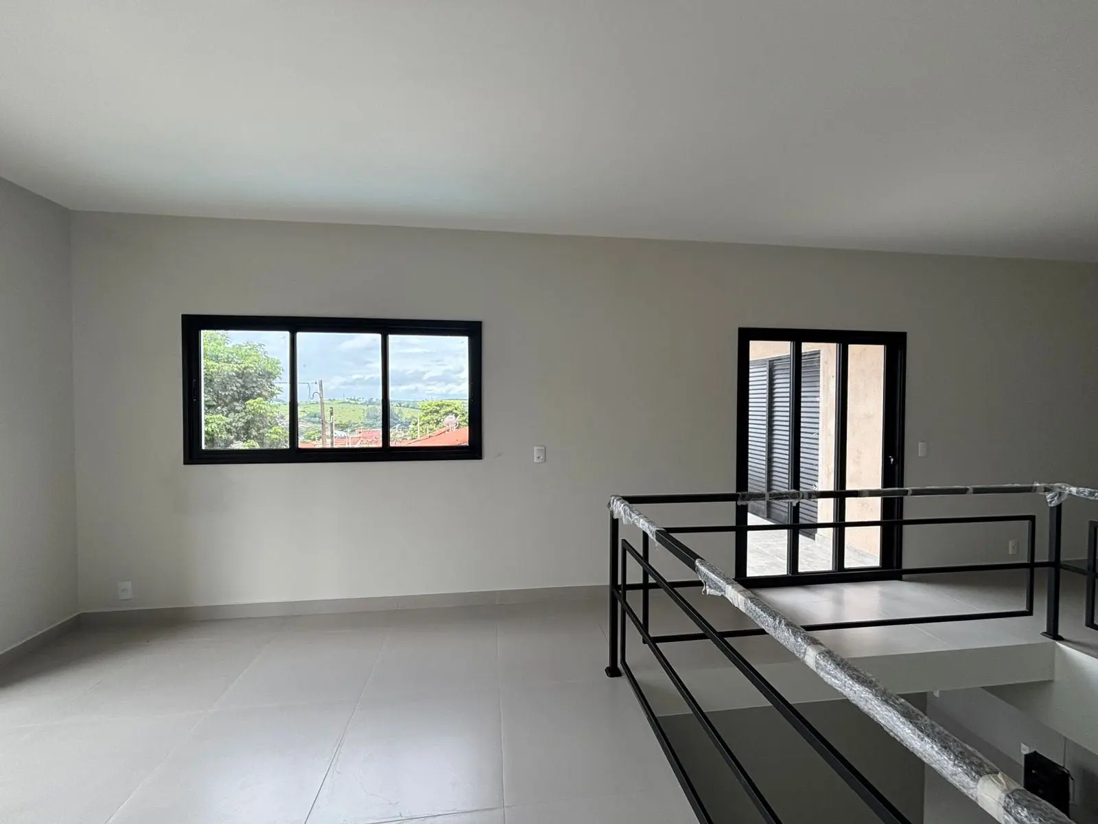 Mezanino com guarda-corpo de alumínio preto, janela e porta de correr