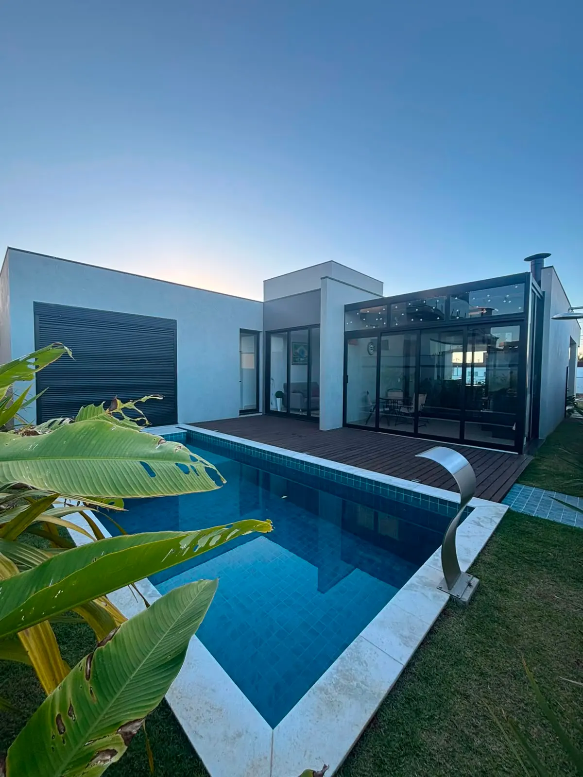 Área gourmet fechada com vidro e esquadrias de alumínio preto ao lado da piscina, executada pela BomBox Vidraçaria